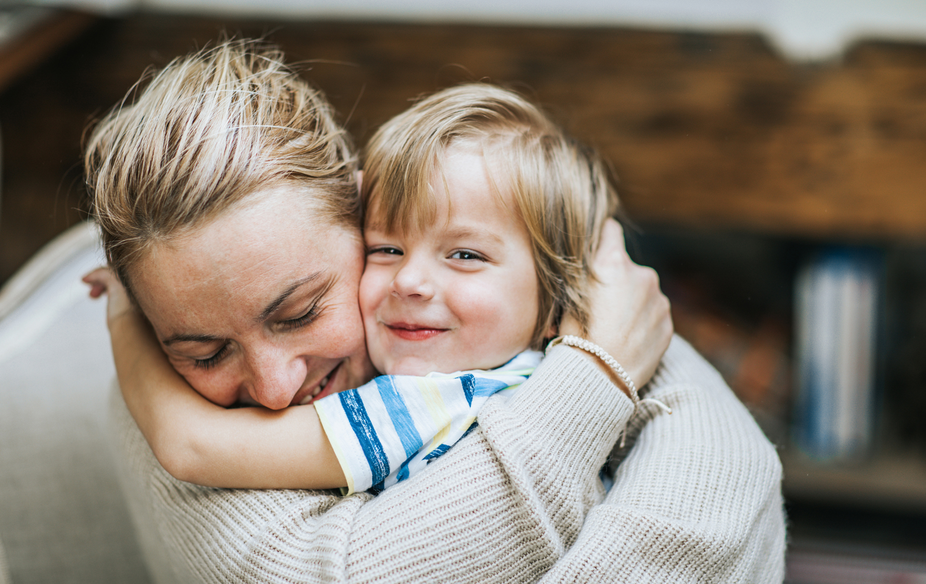 En kvinde og en dreng der krammer